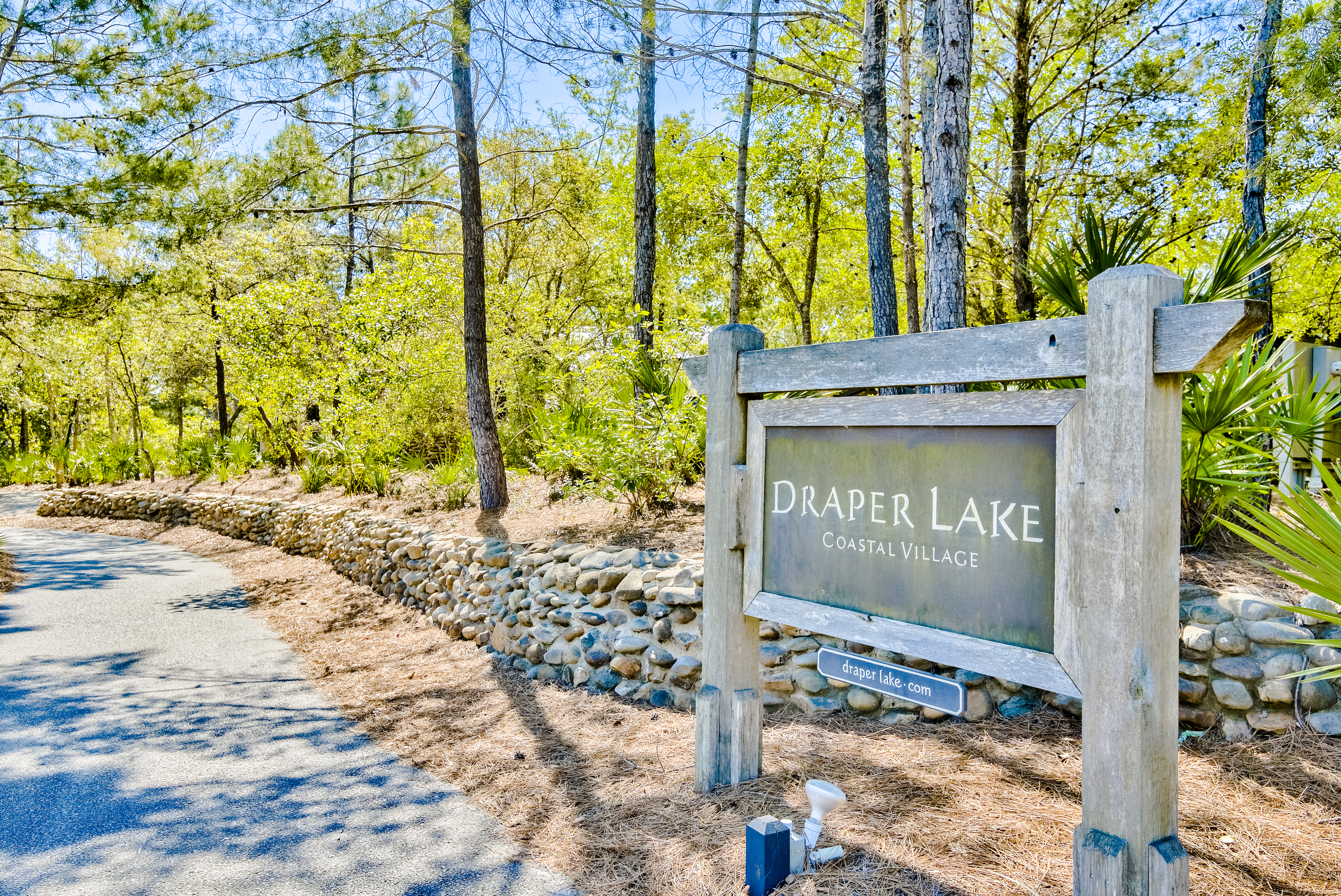 The entrance sign surrounded by forest at the gated Draper Lake community